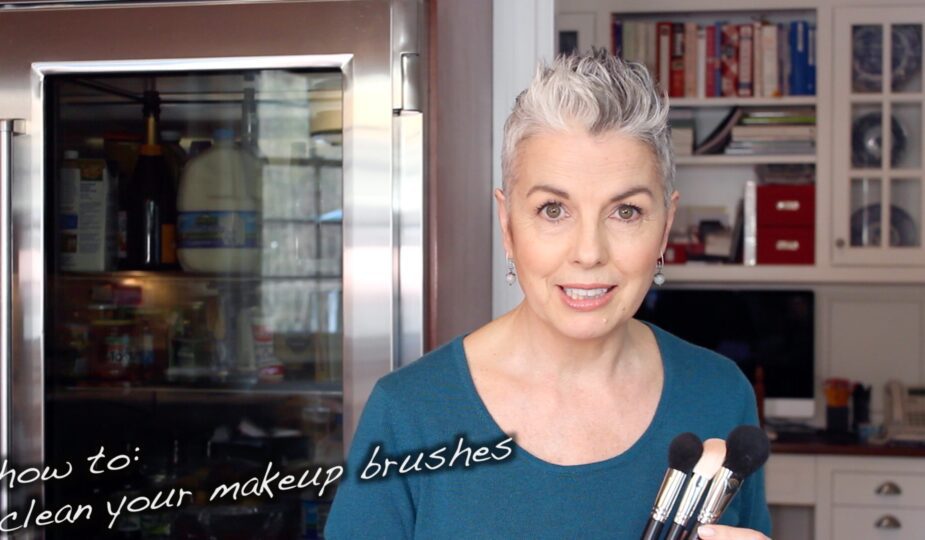 A woman holding makeup brushes.