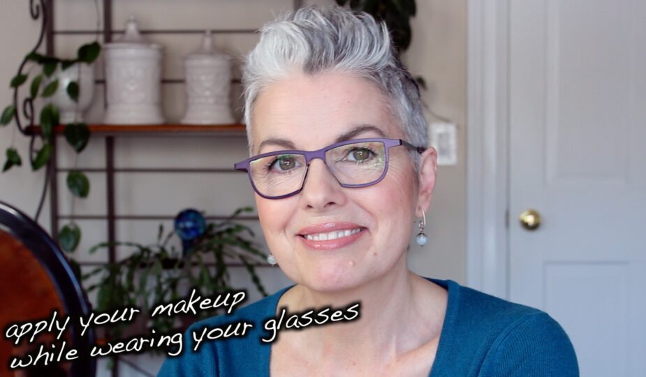 A woman with glasses smiling.