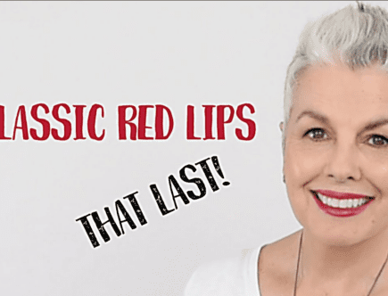 A woman with white hair and red lipstick.