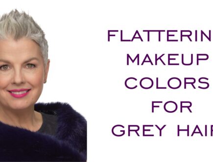 A woman with grey hair and purple lipstick.