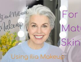 A mature woman smiling at the camera during a makeup tutorial for mature skin.