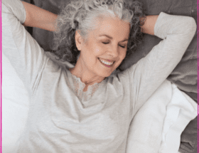 A Woman Lying on a White Color Bed Smiling